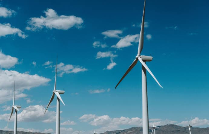 Aerogeneradores del Parque Eólico Pampa Fidelia vistos desde abajo contra un cielo despejado